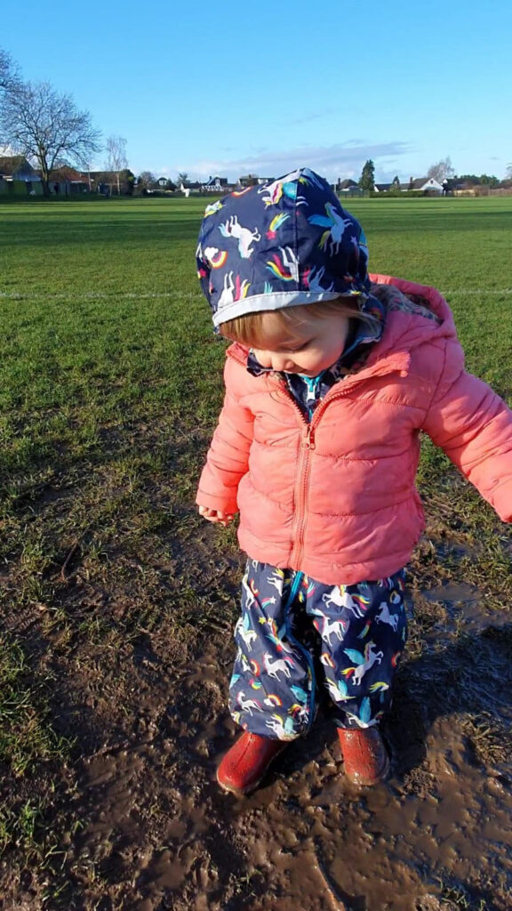 Little girl plays in the mud