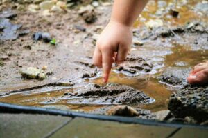 child's hand in mud